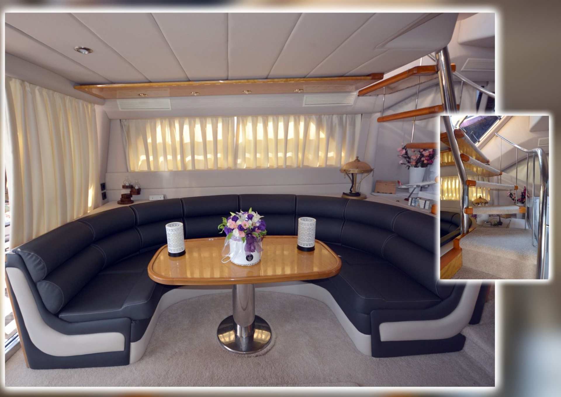 Interior seating area with curved black and white sofa and wooden table on Regnum Yacht