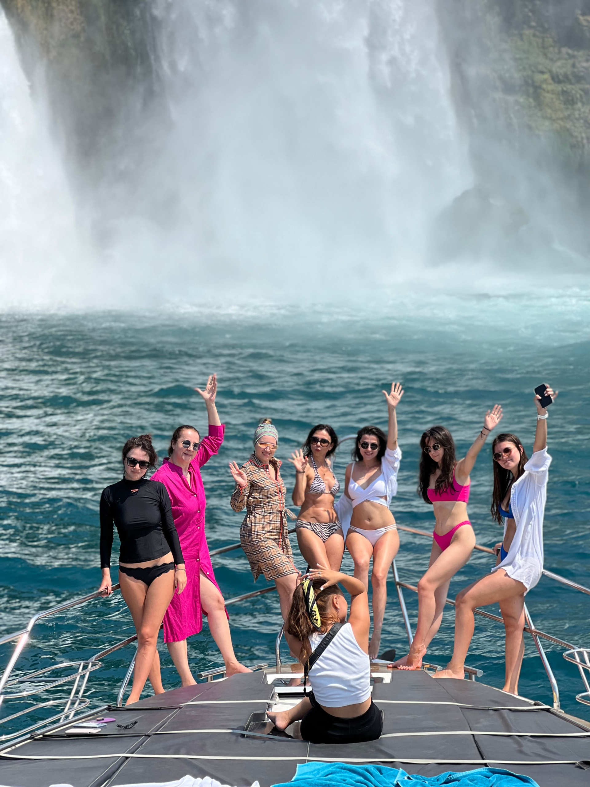 Group of women enjoying the bow of the Regnum Yacht Tour Antalya Private Charter Experience with waterfall in background