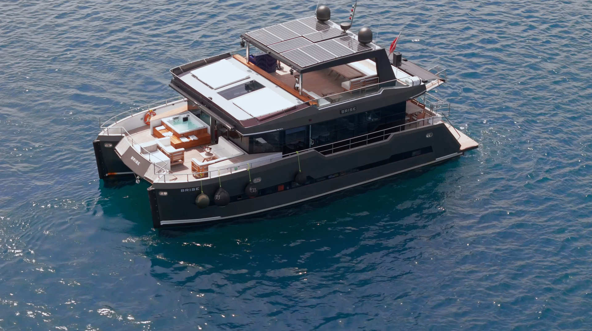 Brise Yacht catamaran floating on calm blue water with visible deck and upper structure