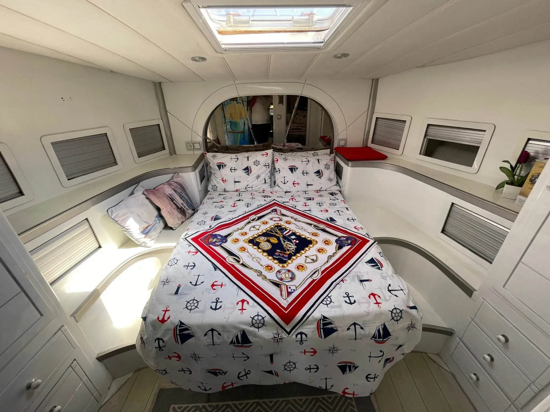 Interior cabin with double bed on Ata 36 yacht, featuring nautical-themed bedding and skylight.