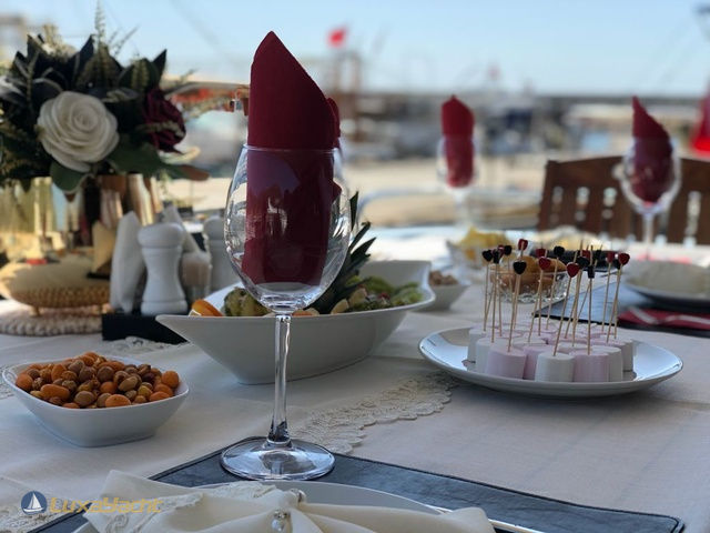 Elegant table setting on Regnum Yacht with glass and red napkin