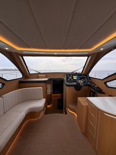 Interior view of Melinda Yacht showing seating area and helm with sea visible through windows