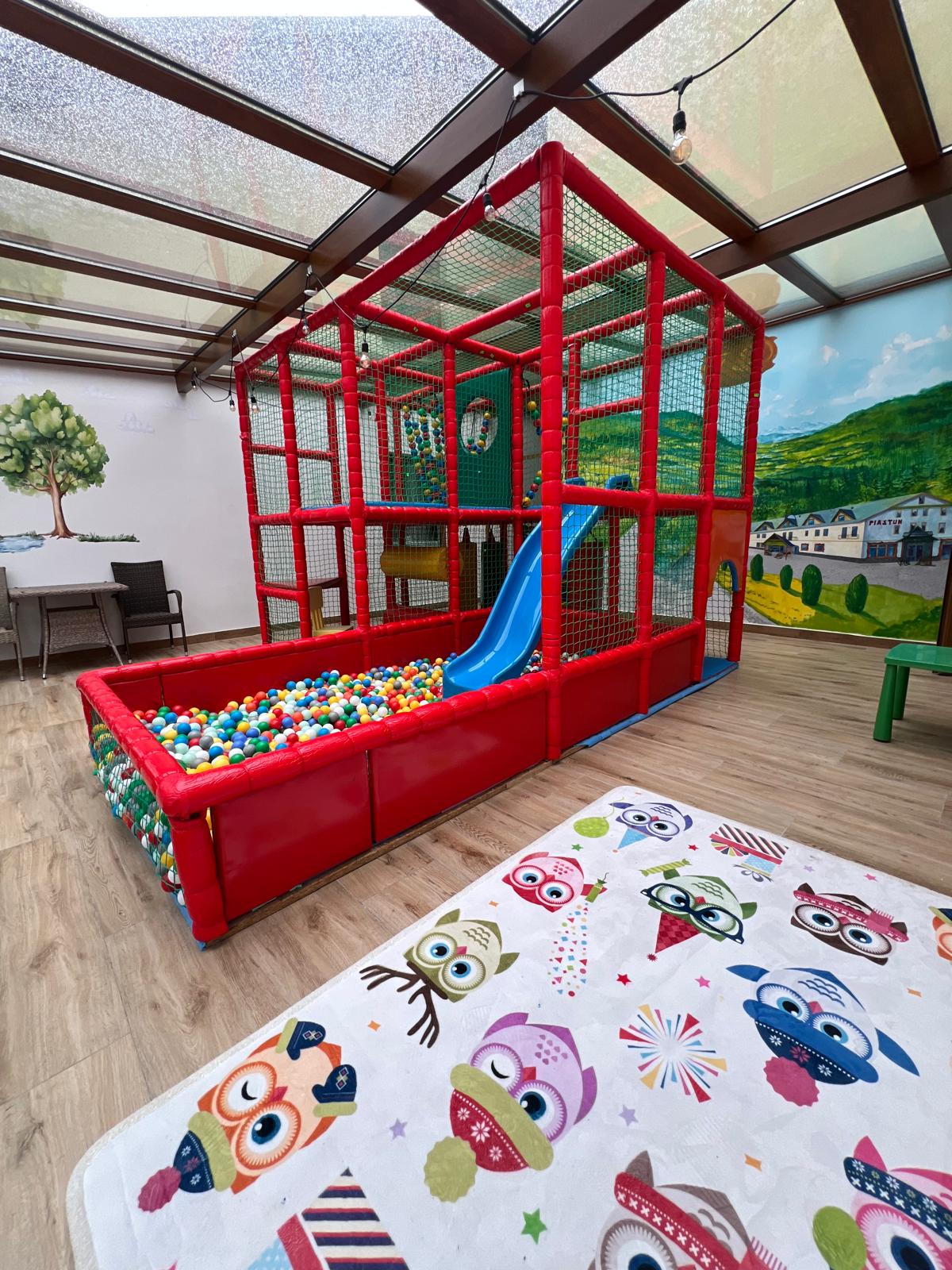 Wewnętrzny plac zabaw dla dzieci z basenem z kulkami i zjeżdżalnią w PIASTUN SPA