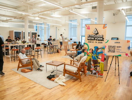 People work and relax in a bright, modern co-working space with an ETHGlobal New York event sign in the foreground.
