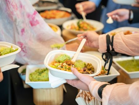 Coworkers choosing lunch from a workplace dining buffet