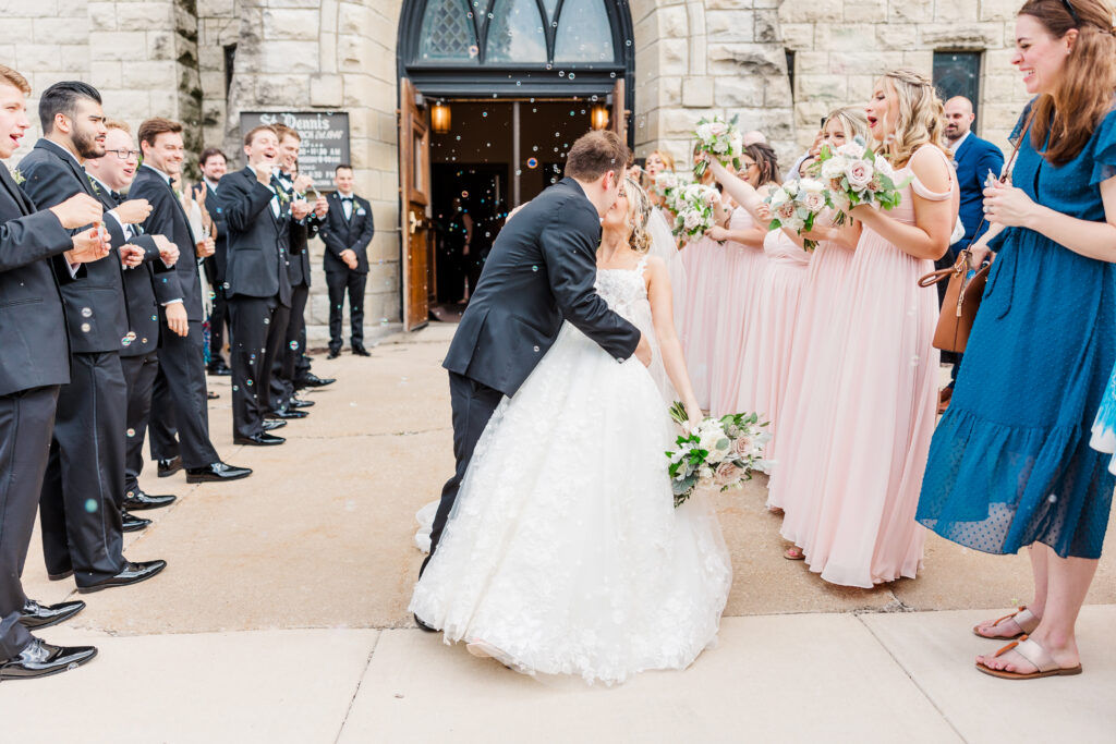 bride and groom kissing outside of church