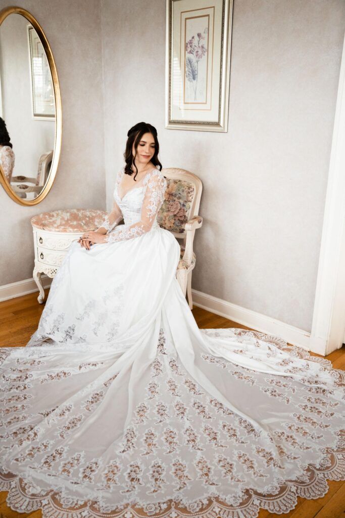 Bride with lone flowing gown posing in a chair.