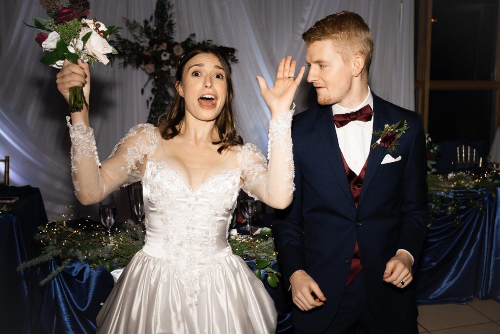Newlyweds dancing, bride holding bouquet.