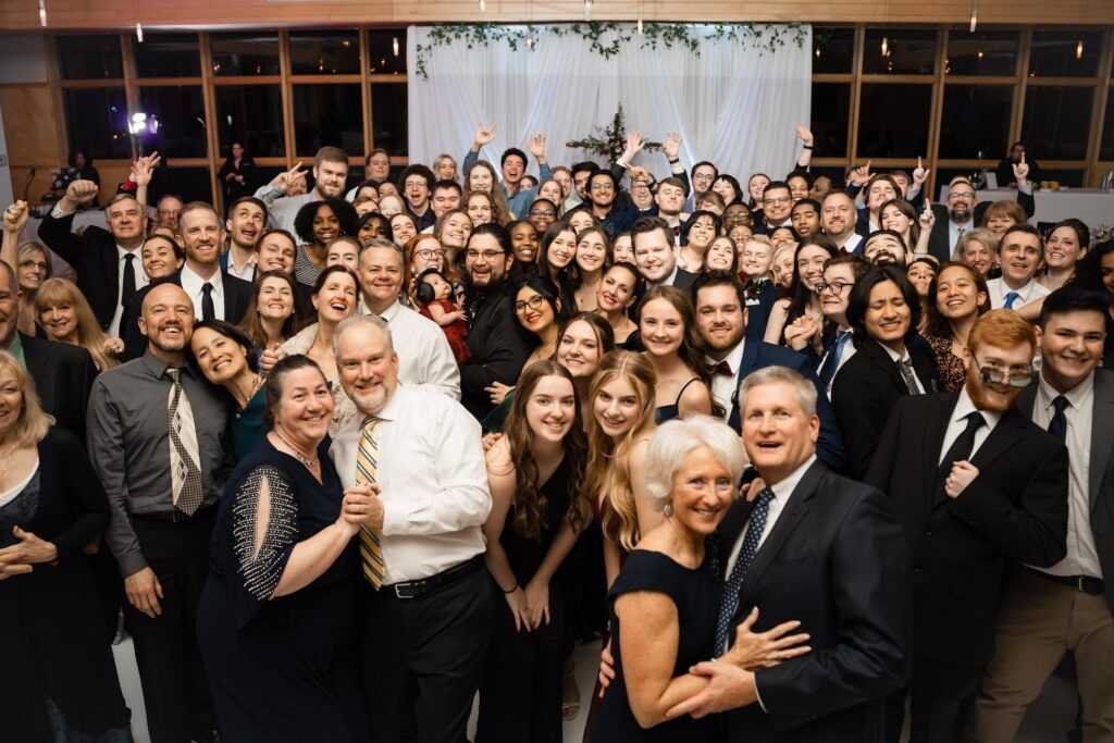 Guests on dance floor posing for group photo.
