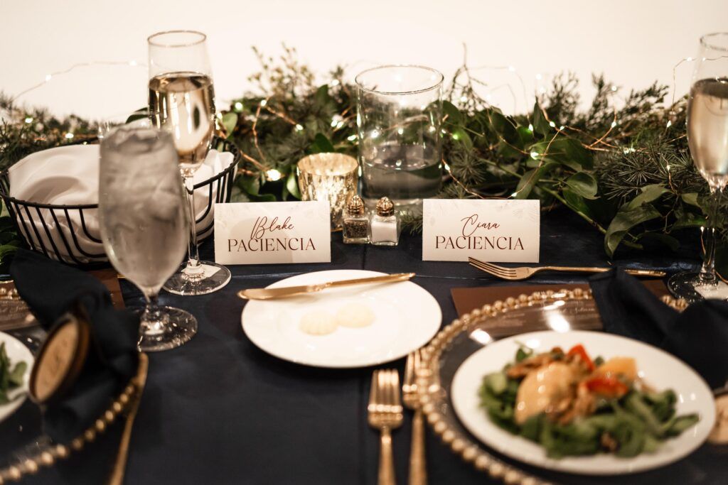 Evergreen centerpiece with table settings and salads.