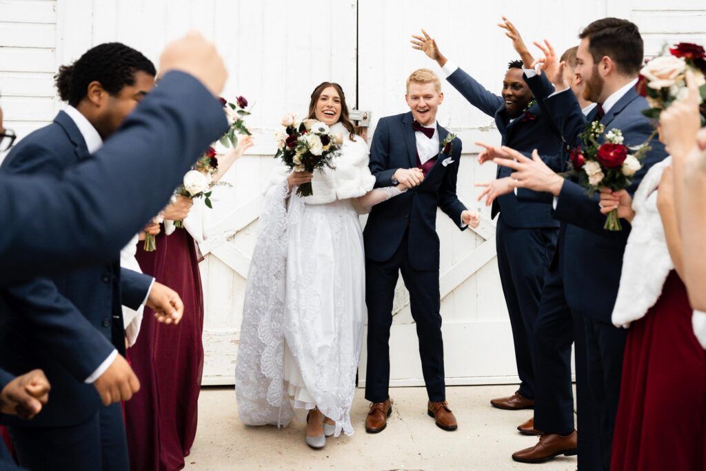 Newlyweds walking through bridal party.
