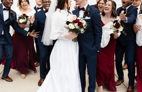 Newlyweds and bridal party outside.