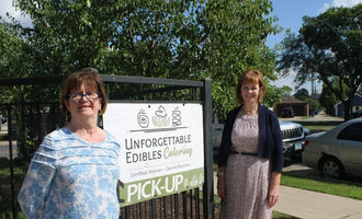 Unforgettable Edibles owners in front of signage