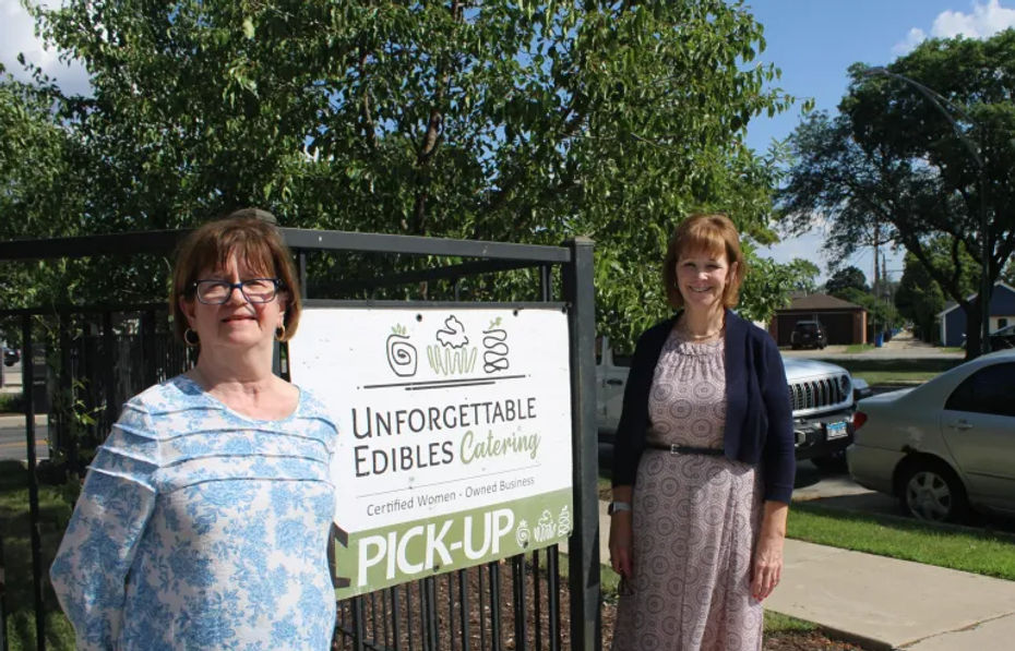 Unforgettable Edibles owners in front of signage