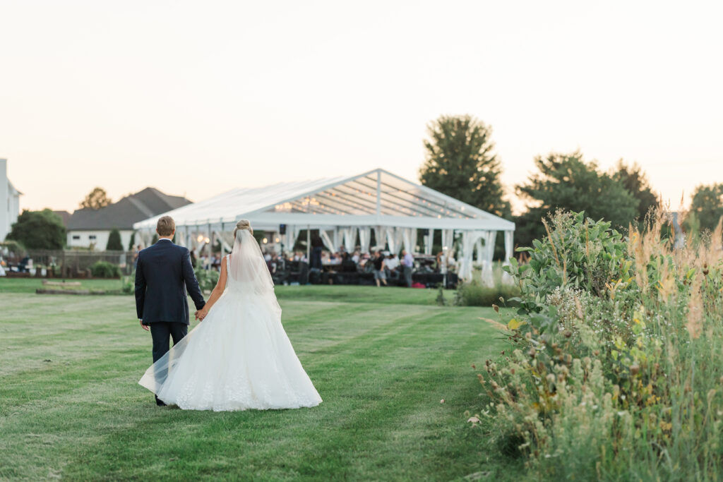 bride and groom approaching tent