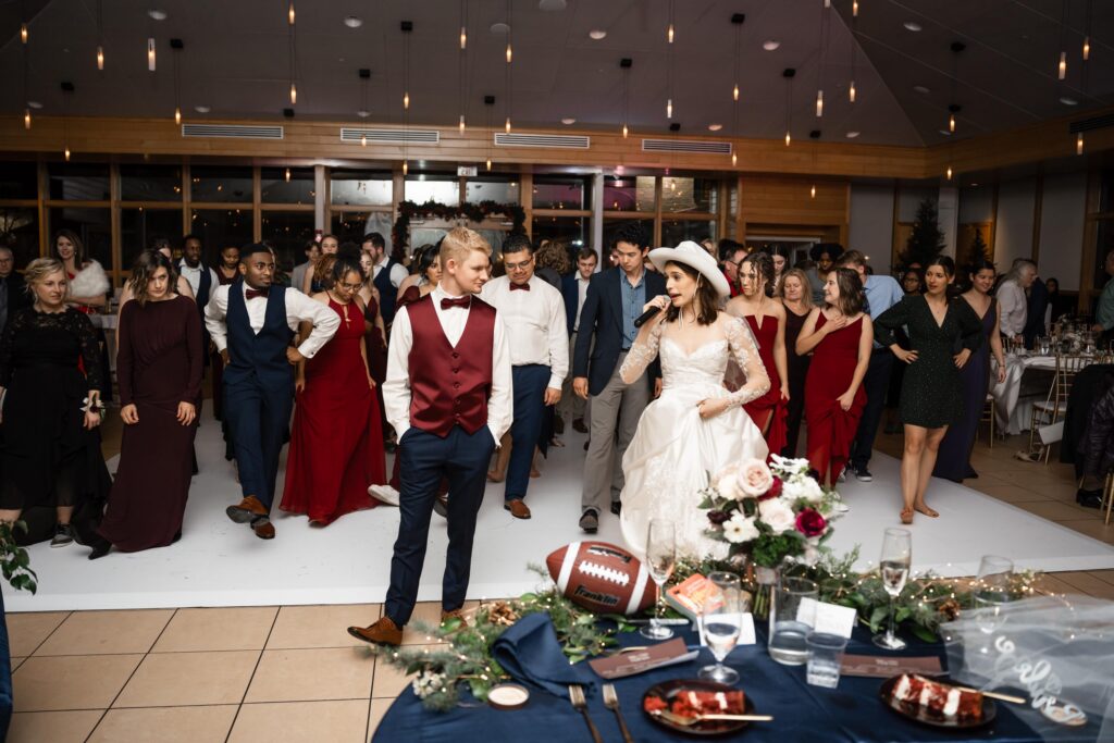 Newlyweds line dancing with guests at reception.