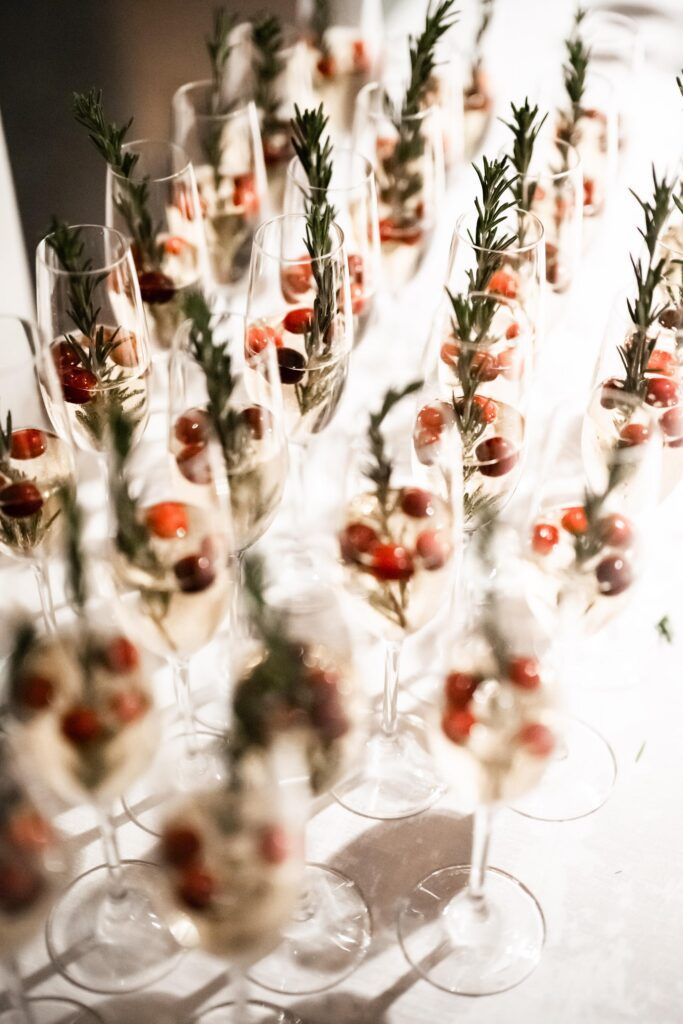 Champagne glasses with rosemary and cranberries.