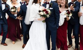 Newlyweds and bridal party outside.
