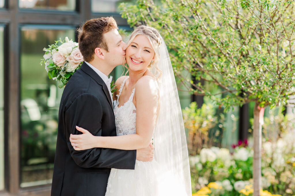 groom kissing bride on cheek