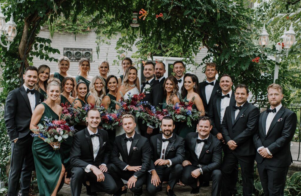 Bridal party grouped under trees.