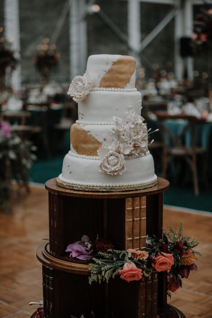 Tiered cake with flowers on a cake table.