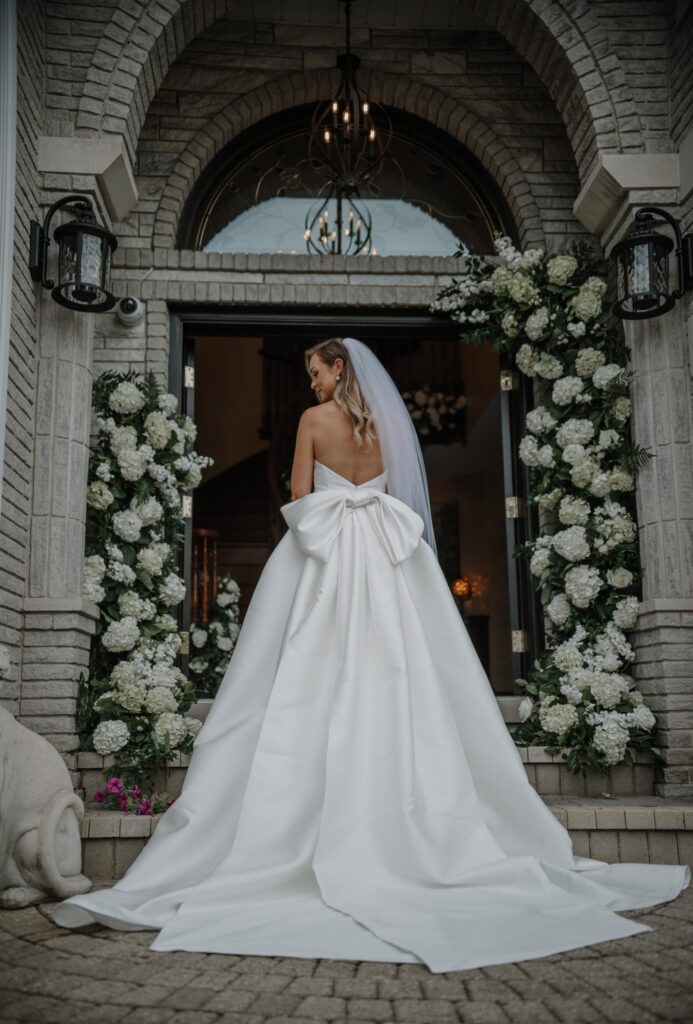 Bride in doorway adorned with floral.