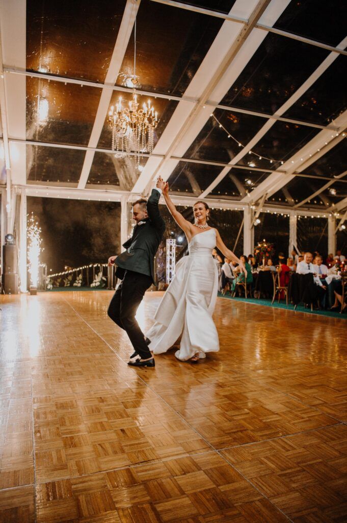 Newlyweds first dancing, groom spinning bride.