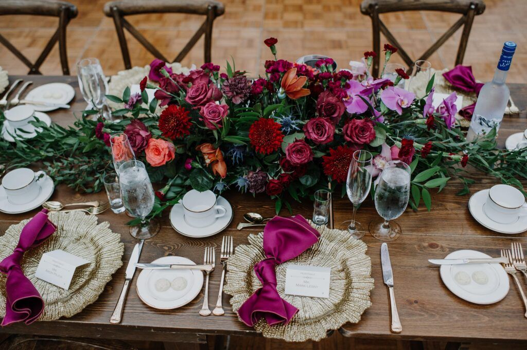 Table setting and low centerpiece, lush florals