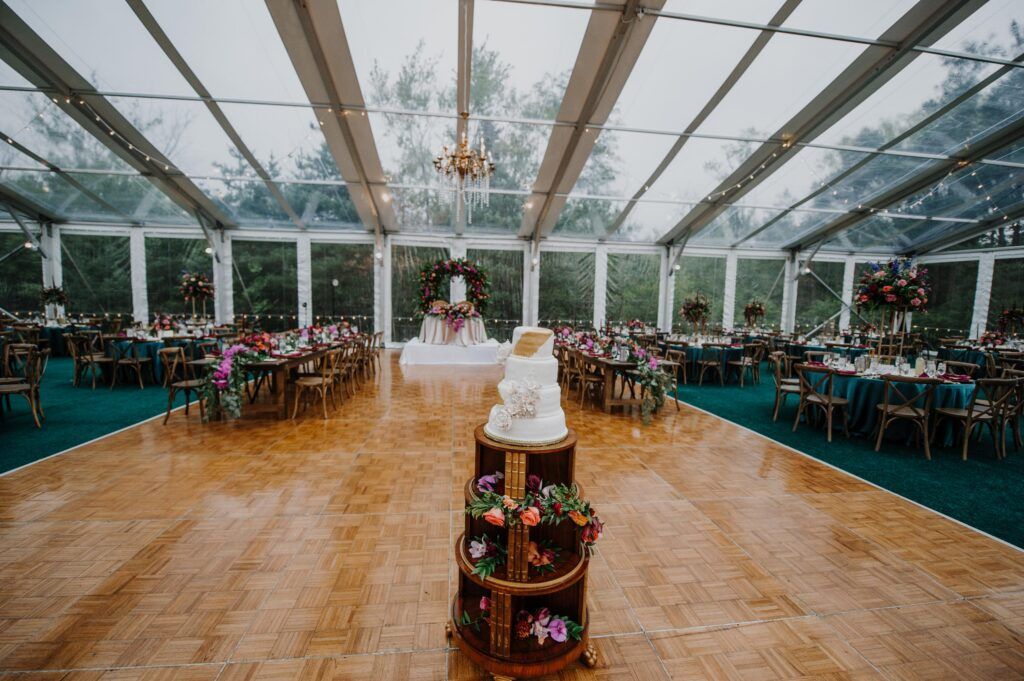 Dance floor with cake and rolling cake table adorned with flowers.