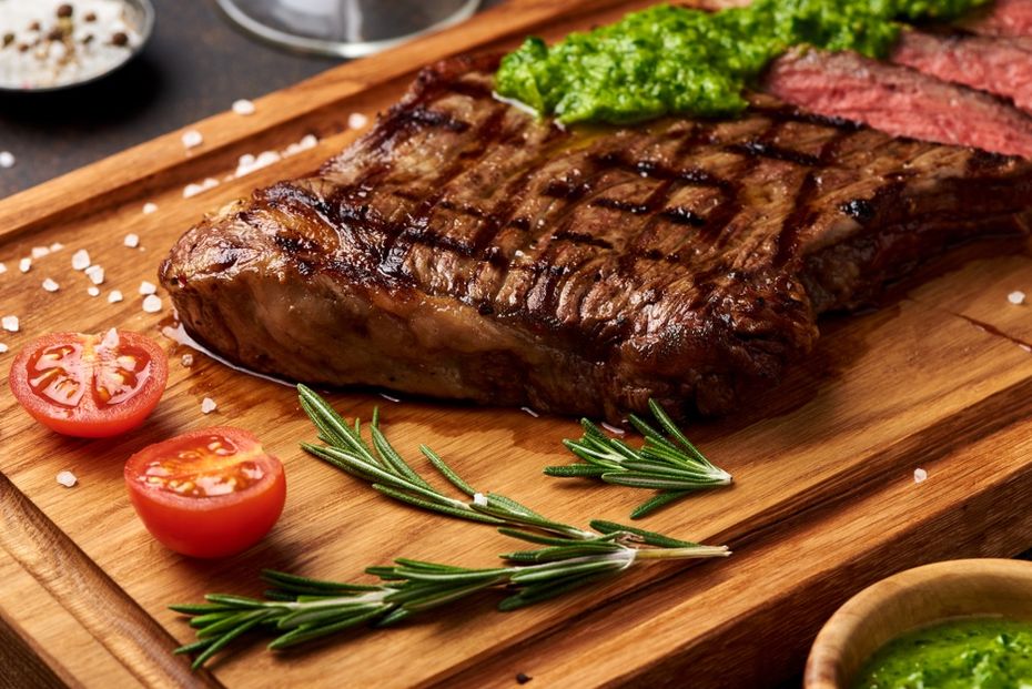 Black Angus roasted sirloin on a cutting board with herbs