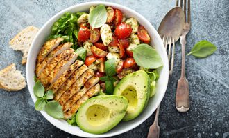 Healthy salad with grilled chicken, avocado and tomatoes