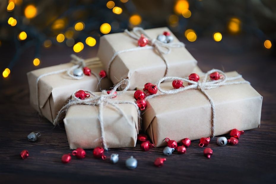 Gifts wrapped in white paper with holiday decorrations