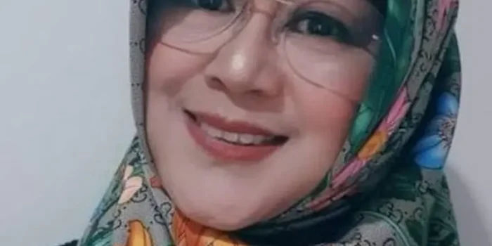 Dokter Tifa mengenakan hijab sedang berjalan atau berada di depan gedung kepolisian sebagai ilustrasi wajib lapor.