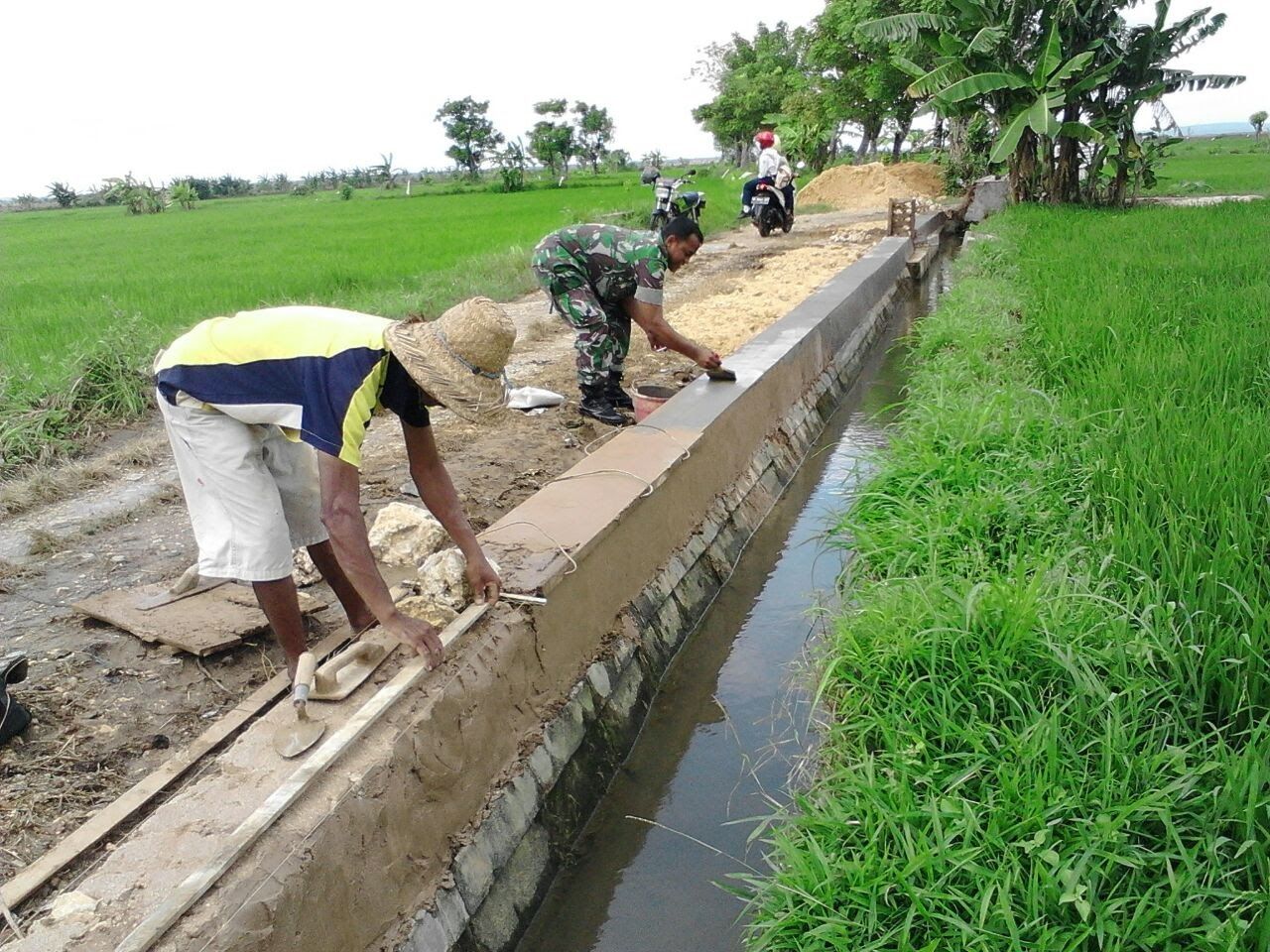 Babinsa Bantu Warga Plamir Saluran Air Irigasi Di Sawah Babinsa Bantu Warga Plamir Saluran Air Irigasi Di Sawah