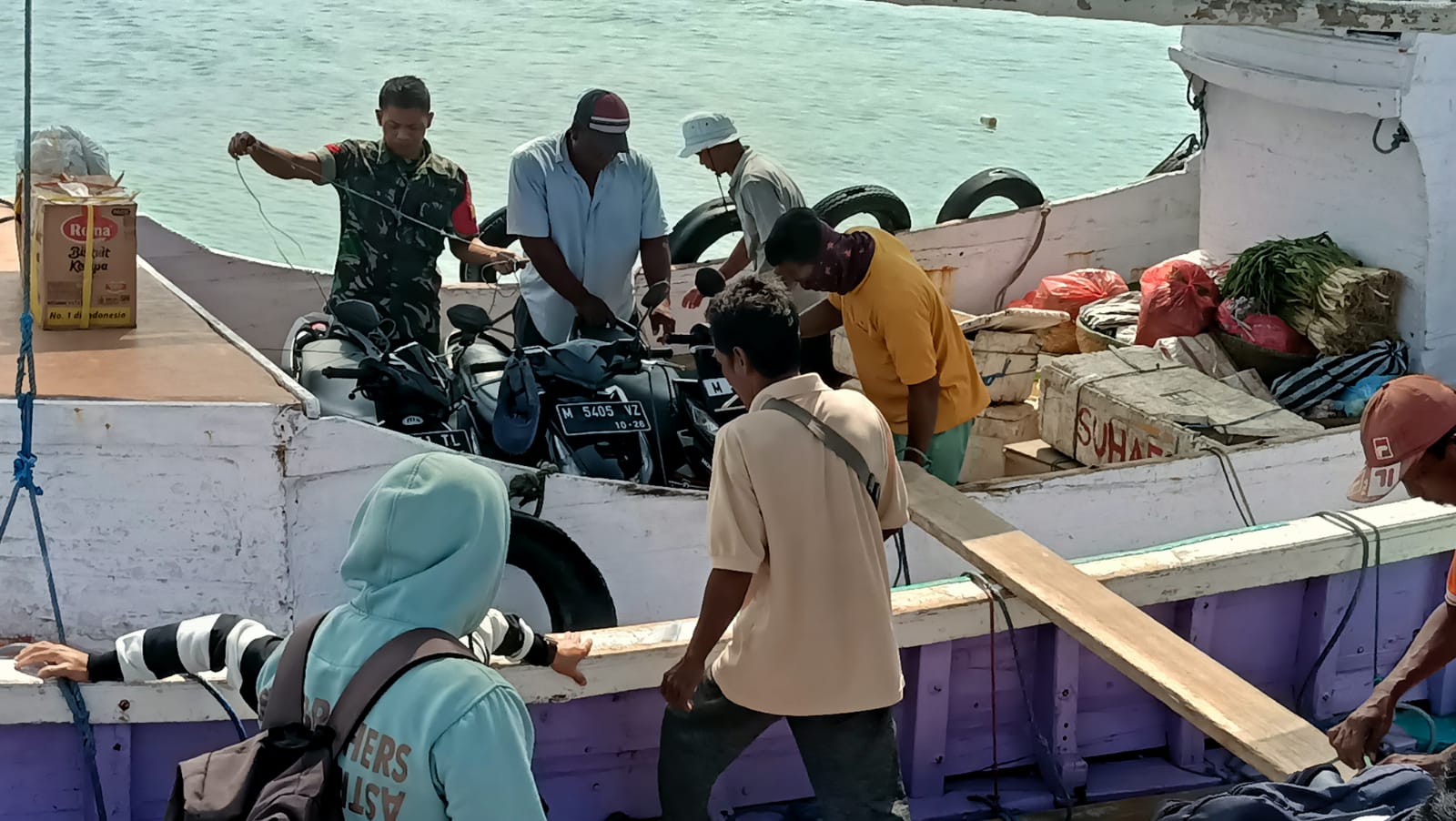 TNI Bantu Masyarakat Naikkan Motor Dari Perahu Ke Pelabuhan Sumenep