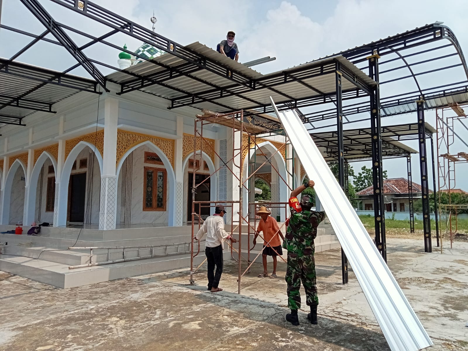 Melalui Gotong Royong, Babinsa Bantu Warga Pasang Atap Teras Masjid At-Taqwa