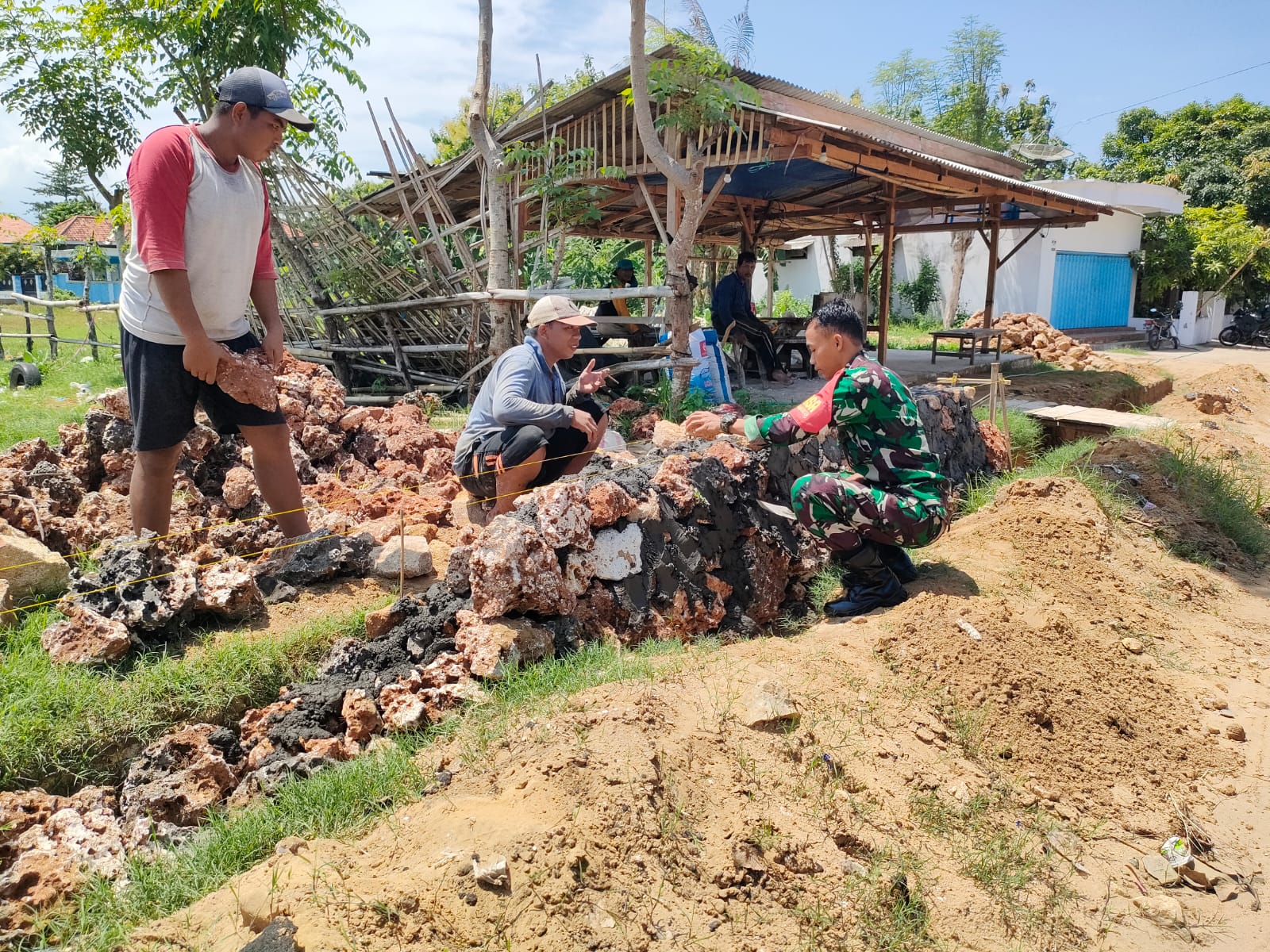 Wujud Kepedulian, TNI Bantu Warga Membuat Pondasi Pagar Bangunan di Lahan Pak Yusuf