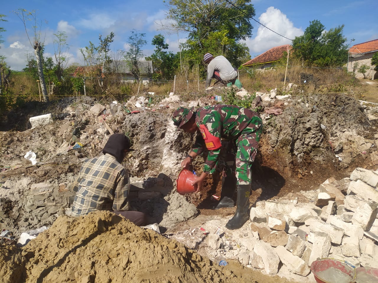 Bangun Keakraban di Wilayah, Babinsa Koramil 11/Pasongsongan Bantu Warga Buat Pondasi Rumah