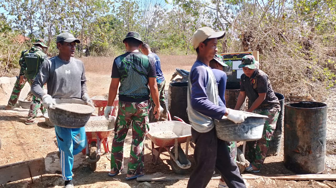 Penuh semangat Personel TMMD dan warga gotong royong angkut pasir Untuk Rabat Jalan Beton