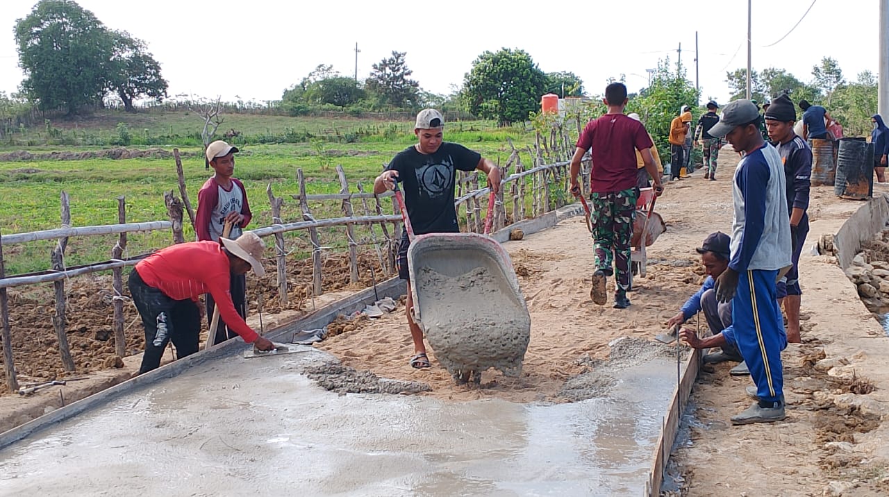 Anggota Satgas TMMD 121 Bahu Membahu Dengan  Warga Angkut Campuran Cor Rabat Beton Dengan Arco