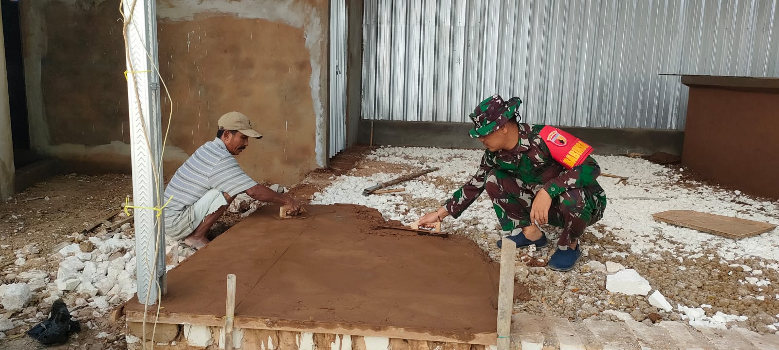 Wujud Kepedulian Babinsa Bantu Plester Teras Rumah Milik Warga