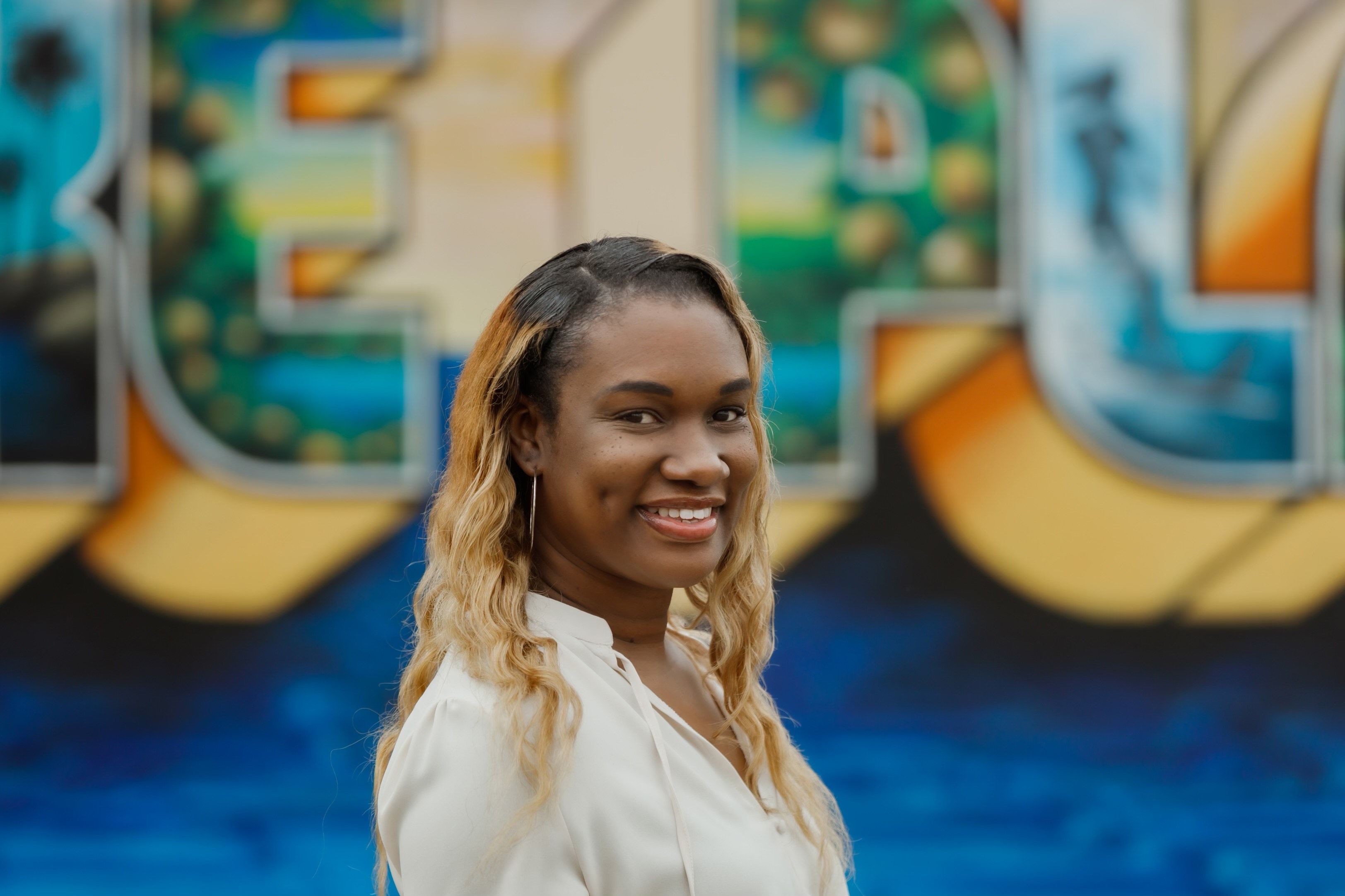Headshot of Mae Doula Olivia, multicolor background.