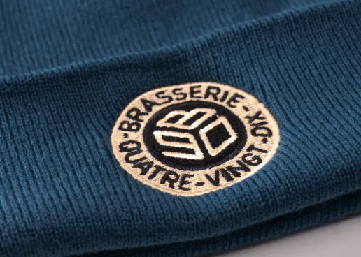 Broderie sur un bonnet bleu pétrole