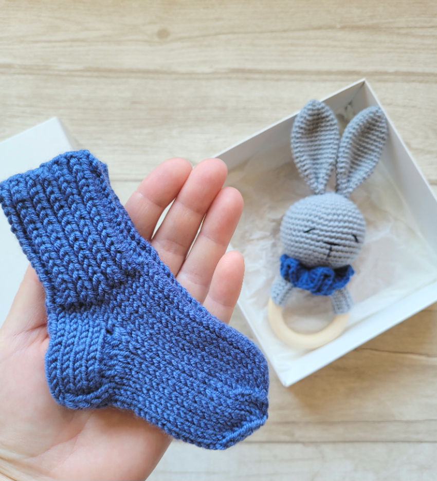 Kramtuko barškučio ir kojinaičių komplektas kojinaitės 9 cm dovanų dėžutėje Dovanos | naujagimiams | kramtuko barškučio ir kojinaičių komplek