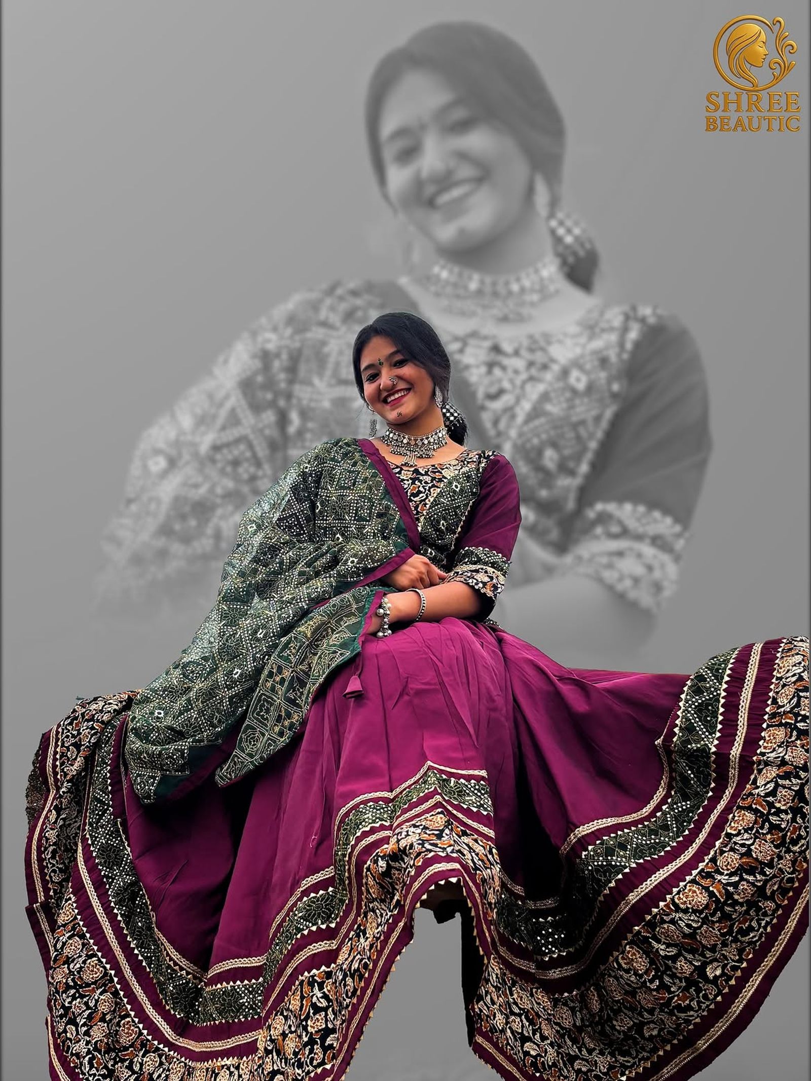 Model seated in a wine-maroon lehenga with black floral borders and a dark green bandhani dupatta