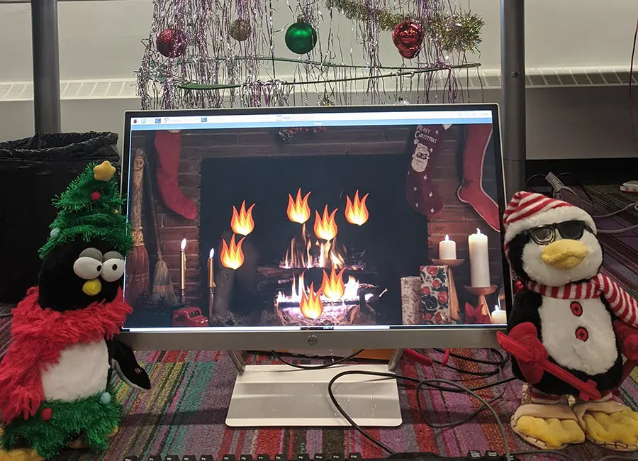Desktop monitor showing flames and two dancing penguins