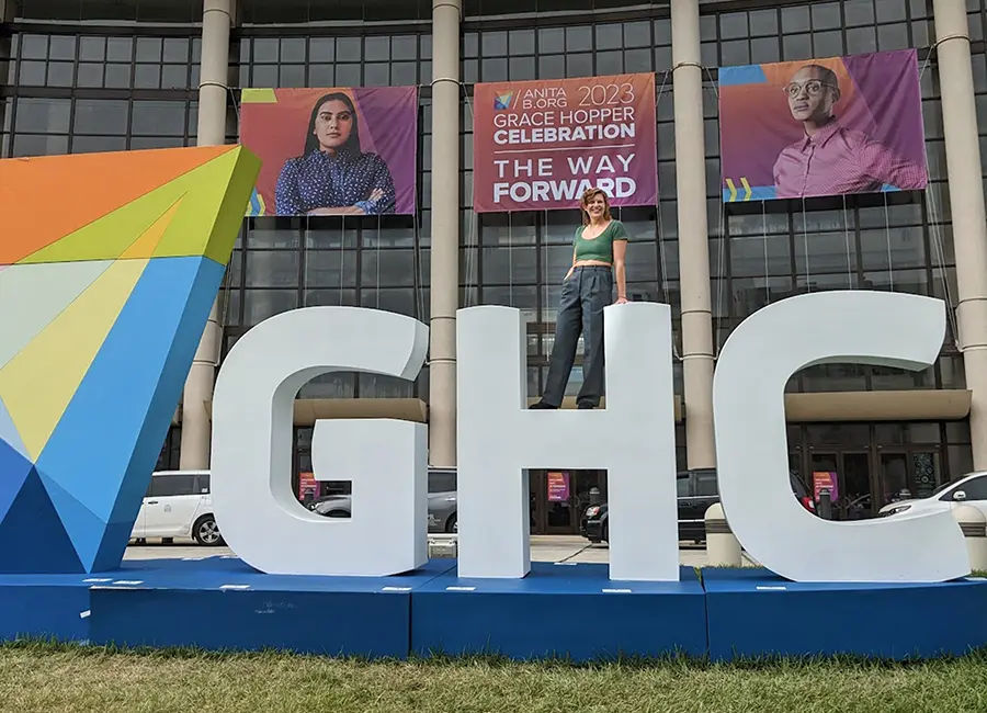 Mandy standing on top of a sign that says GHC