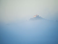 Een kasteel torent uit boven de mistbank. © Billy Herman