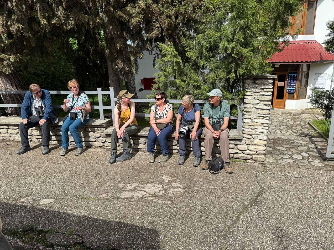 Een deel van de medereizigers van links naar rechts: Willi, Elvire, Eefje, Ann, Mireille en Herman op het muurtje voor het huis van het reservaat. (Ilse, Pieter en Brecht mankeren). © Jan Heip