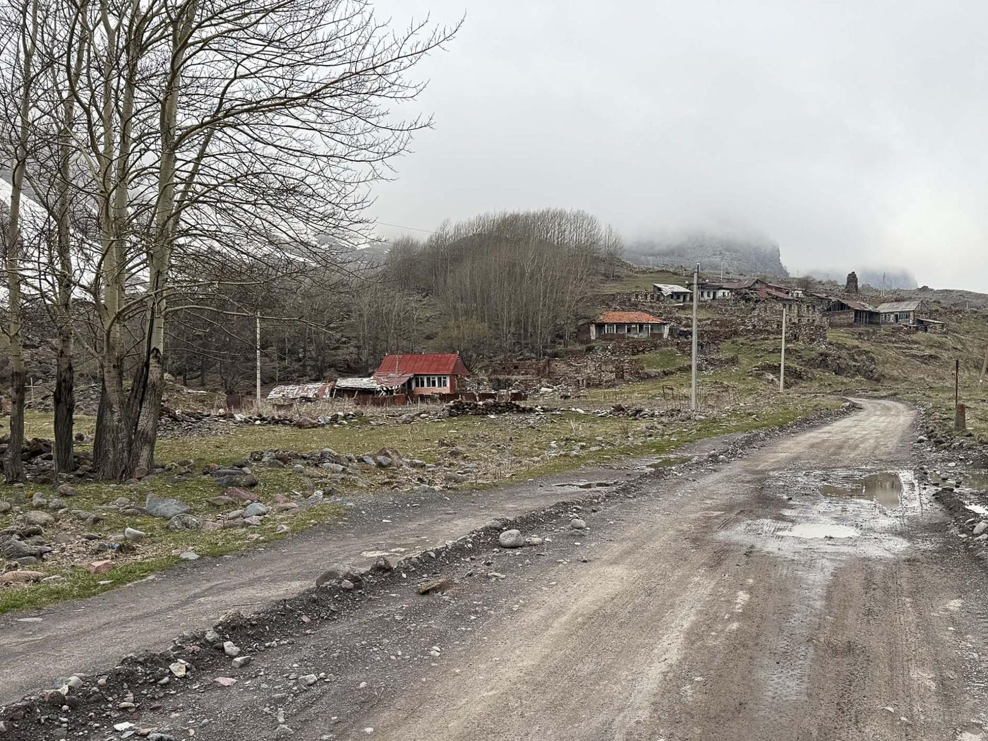 Het verlaten dorp Nogkau met links de bomen van het kerkhof (nog niet in blad). © Jan Heip